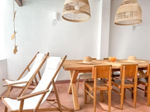 una sala da pranzo con tavolo e sedie in legno di Costa Inn Beach House with Pool by Homeful Homes a Costa da Caparica