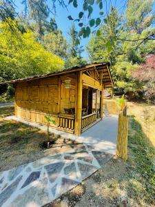 a wooden cabin with a porch in a park at Suite Bambou Bien-être à Bali - Le soleil des Cévennes in Saint-Jean-du-Gard +21 photos
