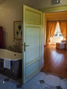 a bathroom with a bath tub next to a door at Hotel Villa Casanova in Lucca