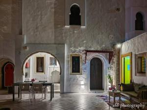 a room with a table and chairs in a building at Maison Leila chambres d hotes in Midoun
