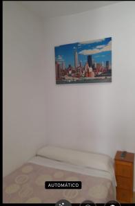 a bed in a room with a picture on the wall at Pensión LF No Fumadores - Sin Ascensor in Zaragoza