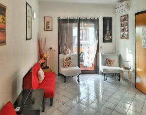 a living room with a red couch and two chairs at 2 bedrooms apartement with sea view furnished terrace and wifi at Olbia 5 km away from the beach in Olbia