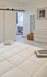 een woonkamer met witte vloeren en een spiegel bij 2 bedrooms apartement with sea view furnished terrace and wifi at Olbia 5 km away from the beach in Olbia