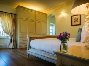 a bedroom with a bed and a table with flowers at Hotel Villa Casanova in Lucca