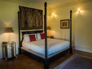 a bedroom with a four poster bed with a painting on the wall at Hotel Villa Casanova in Lucca