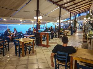 a man sitting at a table in a restaurant at The Blue House in Loutro