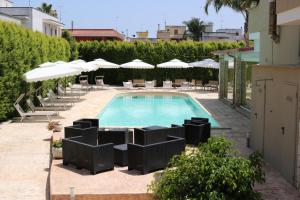 a swimming pool with chairs and umbrellas at b&b Villa Grazia in Leverano