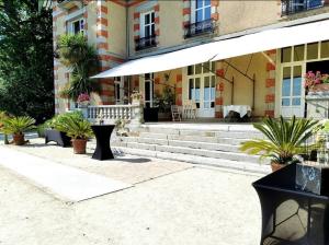a building with potted plants in front of a building at Suite Napoléon 3, vue Mont St Michel, avec balcon in Saint-Jean-le-Thomas