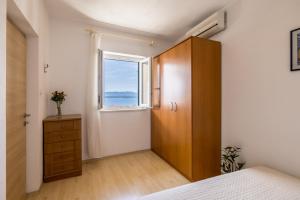 a bedroom with a wooden cabinet and a window at Viola in Bol
