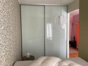 a bedroom with a glass partition with a bed at Kooli in Pärnu