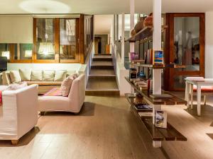 una sala de estar con muebles blancos y una escalera. en NOI Casa Atacama, en San Pedro de Atacama