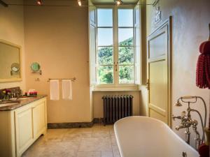 a bathroom with a white tub and a window at Hotel Villa Casanova in Lucca
