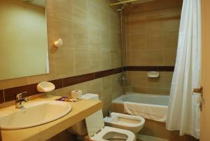 a bathroom with a sink and a toilet and a tub at Silenios in Pinamar +41 photos