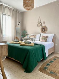 a bedroom with a large bed with a green blanket at Davanti al Mare in Epanomi