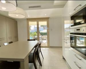 a kitchen with a large white table and chairs at Vistamar in Les tres Cales