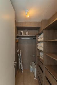 a walk in closet with wooden shelves and towels at Kennedy Premium Apartments in Santiago