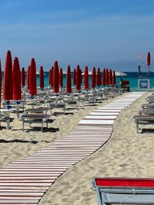 una fila di ombrelloni e sedie rossi su una spiaggia di Villetta Salento a Torre Lapillo