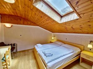 una camera con un grande letto e un lucernario di Villa Flora by AMA Val di Fassa a Canazei Altre 54 foto