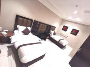 um quarto com uma cama grande e uma secretária e uma cama sidx sidx sidx em Ashbonh Hotel Suites em Riade