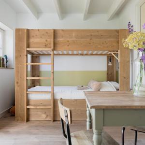 a bedroom with a wooden bunk bed with a table at De Sleeuwijkerwaard in Sleeuwijk