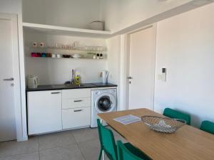 a kitchen with a table and a washing machine at Apartman Levantara in Murter