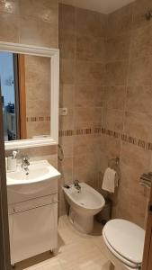 a bathroom with a sink and a toilet and a mirror at Apartamento costa azahar l 2 linea playa zona marina Dor in Oropesa del Mar