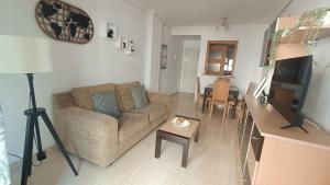 a living room with a couch and a table at Apartamento costa azahar l 2 linea playa zona marina Dor in Oropesa del Mar