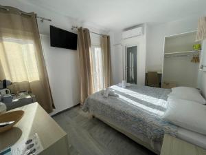 um quarto com uma cama e uma televisão em Ioanna's House em Míconos