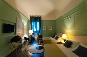 a hotel room with two beds and a couch at I PRINCIPI di CASADOR HOUSE HOTEL in Milazzo