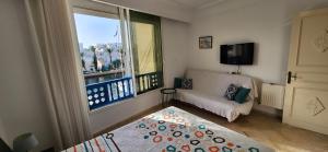 a living room with a couch and a large window at Appartement marina hammamet in Yasmine
