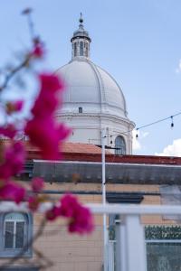 um edifício com uma cúpula em cima com flores cor-de-rosa em Hotel San Michele em Nápoles