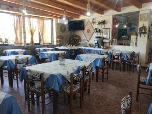 a restaurant with tables and chairs with blue table cloth at agriturismo heaven in Capo Vaticano