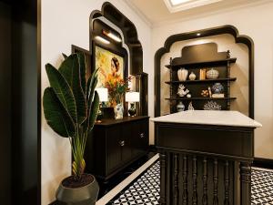 een badkamer met een zwarte kast en een potplant bij Milestone Inn Hotel in Ho Chi Minh-stad