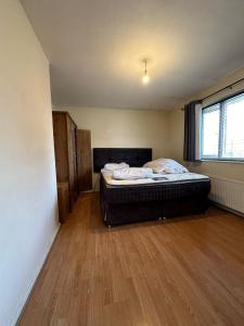 a bedroom with a bed in a room with wooden floors at Home Apartments Stay in Abbey Wood