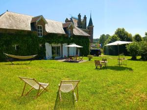 a yard with chairs and a hammock in front of a house at Château Machiel Chambre d hotes de charme au calme en Baie de Somme in Machiel