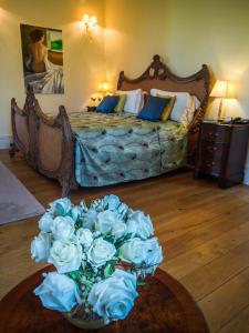 a bedroom with a bed with a vase of white roses at Hotel Villa Casanova in Lucca