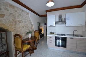 a kitchen with a table and a stone wall at B&B CASAVACANZE CHIESA MADRE in Carovigno