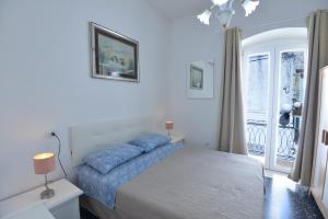 a white bedroom with a bed and a window at B&B CASAVACANZE CHIESA MADRE in Carovigno