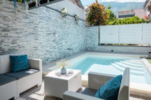 a swimming pool in a patio with chairs and a table at La Perla Luxury Rooms in Angri