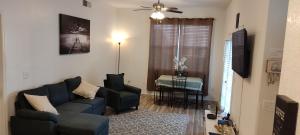 Una sala de estar con un sofá azul y una mesa. en Orlando House, en Kissimmee