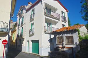 a white building with balconies and a red stop sign at Puig Roja del Roser in Prats-de-Mollo-la-Preste