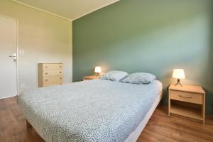 Un dormitorio con una cama con dos mesitas de noche y dos lámparas. en Le Panoramique, en Lourdes