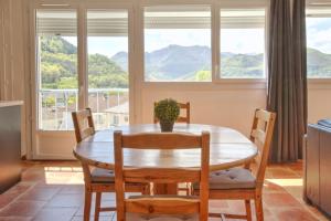 Un comedor con mesa y sillas y ventanas. en Le Panoramique, en Lourdes 7 fotos más