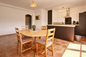 Una cocina y un comedor con mesa y sillas de madera. en Le Panoramique, en Lourdes