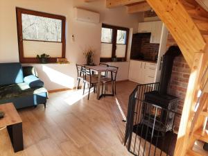a living room with a fireplace and a table with chairs at Domki nad potokiem in Stary Sącz +23 photos