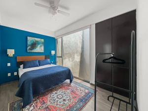 a bedroom with a bed and a blue wall at 70-PH 2BR Roma Notre Penthouse Dplx Private roof in Mexico City