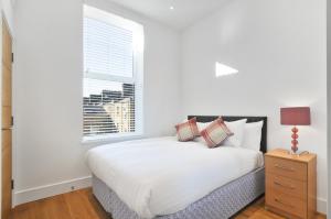 ロンドンにあるAccess West Kensingtonの白いベッドルーム(ベッド1台、窓付)