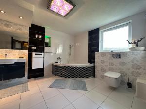 a bathroom with a tub and a toilet and a sink at Chalupa u Vojvodovcov in Zázrivá +26 photos