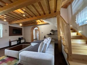 a living room with two couches and a staircase at Chalupa u Vojvodovcov in Zázrivá