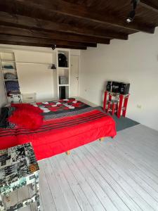 a bedroom with a bed with a red blanket at Duplex Temporario - Zona Dique in Tandil